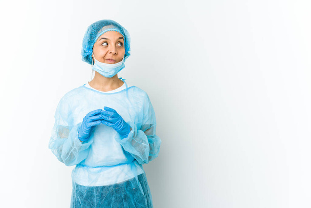 Jonge chirurg latijn vrouw geïsoleerd op witte achtergrond make-up plan in gedachten, het opzetten van een idee. - Foto, afbeelding