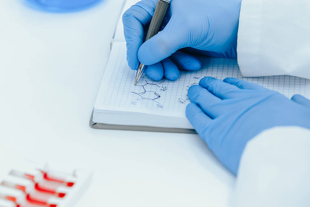 close up. scientist virologist recording test results in a journal. - Photo, image