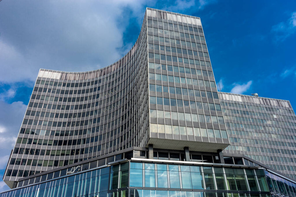 Vysoká skleněná budova s křivkou proti modré obloze v Bruselu, Belgie, Evropa za jasného letního dne s modrou oblohou - Fotografie, Obrázek