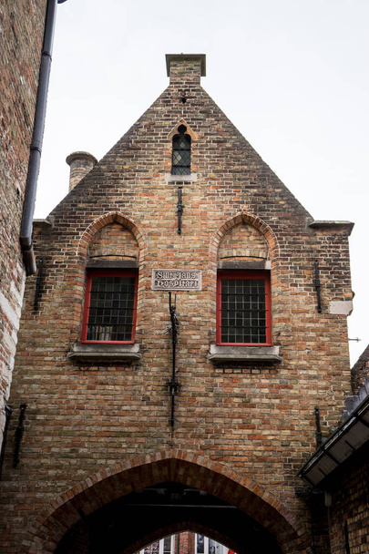 Здание из красного кирпича с фронтоном на вершине арки в Брюсселе, Бельгия, Европа - Фото, изображение