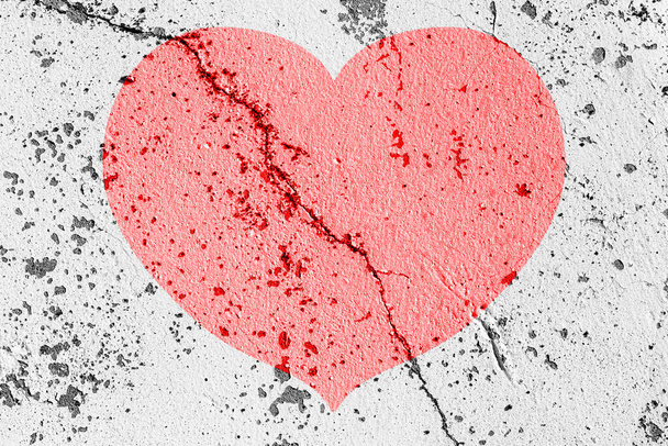 Rode hart op een gebarsten textuur. Het concept van gebroken hart, einde van liefde en teleurstelling. - Foto, afbeelding