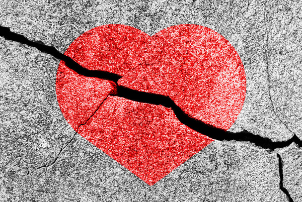 Cuore rosso su una struttura incrinata. Il concetto di cuore spezzato, fine dell'amore e delusione. - Foto, immagini