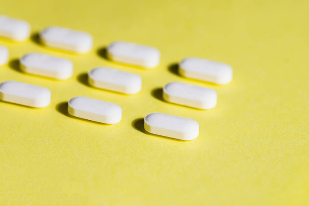 close up. lot of pills on a yellow background. - Foto, Imagem