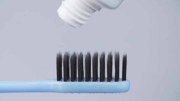 Střelba zubní pasty na zubním kartáčku na bílém pozadí - Záběry, video