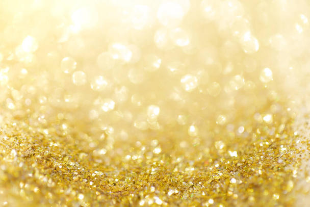 Gold light Festive Christmas background. Abstract twinkled bright background with bokeh defocused golden lights - Photo, Image
