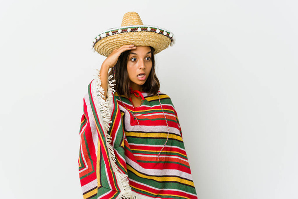 Fiatal mexikói nő elszigetelt fehér háttér néz távol tartja kezét a homlokon. - Fotó, kép