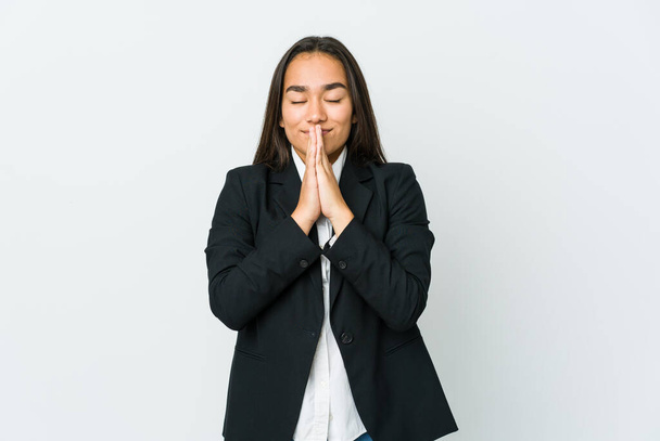 Fiatal ázsiai üzletek nő elszigetelt fehér háttér fogja a kezét imádkozni közel száj, úgy érzi, magabiztos. - Fotó, kép