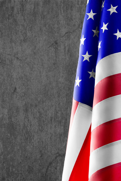 Photo verticale d'un drapeau américain sur fond de béton. Contexte pour créer une carte postale ou une carte d'invitation. - Photo, image