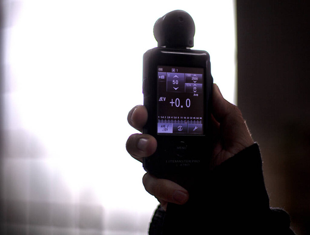 Hand held light meter isolated in studio lights. - Photo, Image