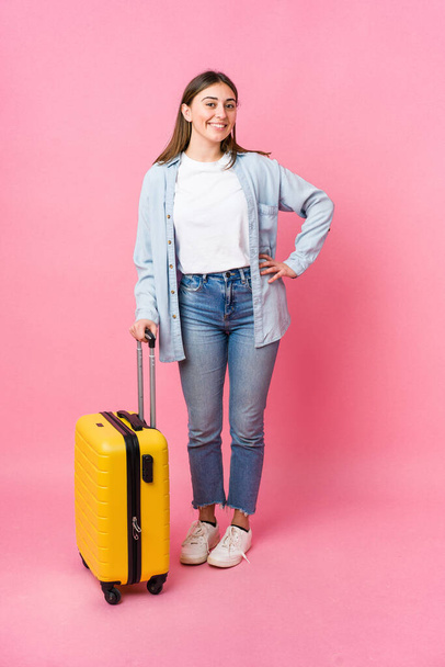 Young caucasian woman going to traveler isolated on pink background - Photo, image