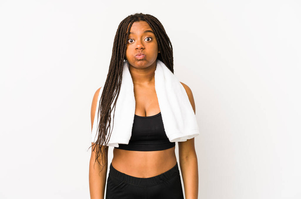 Genç Afrikalı Amerikalı sporcu kadın yalnız, yanaklarına sakso çekiyor, yorgun bir ifade takınıyor. Yüz ifadesi kavramı. - Fotoğraf, Görsel