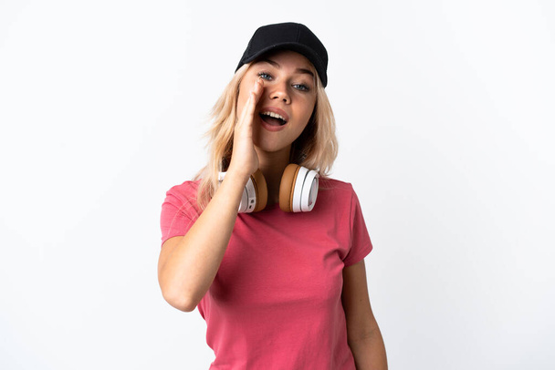 Mladý ruský žena poslech hudba izolované na bílém pozadí křičí s ústy široce otevřené - Fotografie, Obrázek