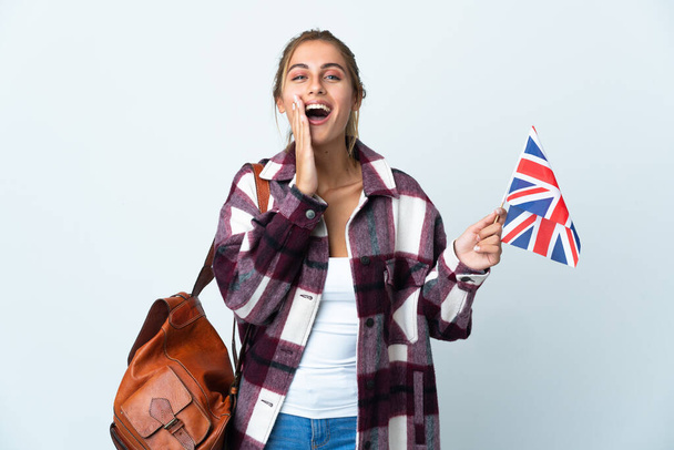 Junge Frau mit einer britischen Flagge auf weißem Hintergrund, die mit weit geöffnetem Mund schreit - Foto, Bild