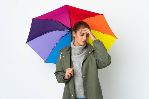 Mladá žena drží deštník izolované na bílém pozadí s bolestí hlavy - Fotografie, Obrázek