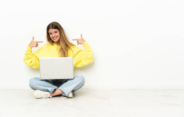 若いです女性とノートパソコンの床に座って親指を上げるジェスチャー - 写真・画像