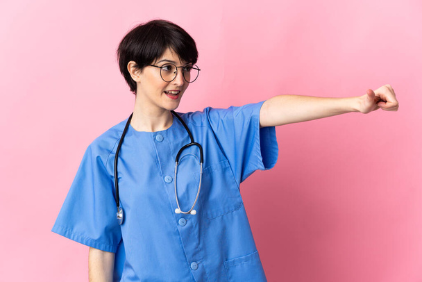 Chirurg isoliert auf rosa Hintergrund mit Daumen-hoch-Geste - Foto, Bild