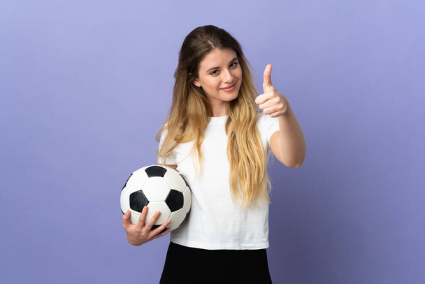 Junge blonde Fußballerin isoliert auf lila Hintergrund mit erhobenen Daumen, weil etwas Gutes passiert ist - Foto, Bild