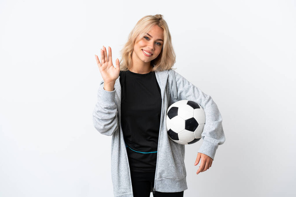 Νεαρή Ρωσίδα που παίζει ποδόσφαιρο απομονωμένη σε λευκό φόντο χαιρετώντας με το χέρι με χαρούμενη έκφραση - Φωτογραφία, εικόνα