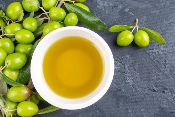 зелені оливки та оливкова олія на сірому фоні
. - Фото, зображення