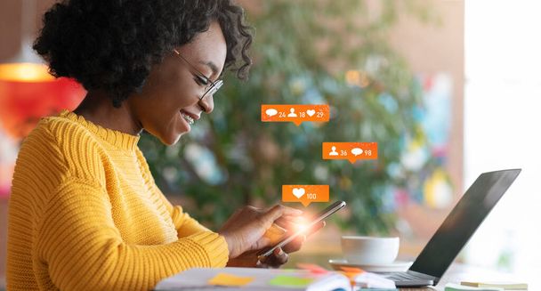 Afrikaanse dame met behulp van laptop sms 'en in Chat zitten in Cafe - Foto, afbeelding