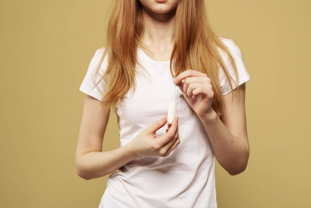 Chica con un tampón en la mano el tamaño de la apariencia de los días críticos de la menstruación - Foto, imagen