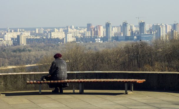 Lonely grandmother sits himself analysis looks at the city bench - Photo, Image