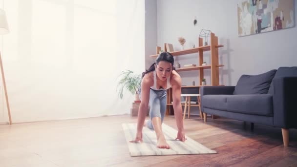 Jonge sportvrouw stretching op fitness mat thuis  - Video