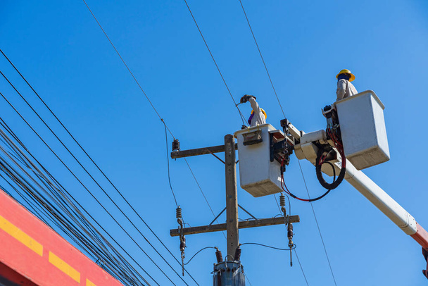 техническое обслуживание электриков, работающих с высоким напряжением электричества на гидравлическом ведре - Фото, изображение