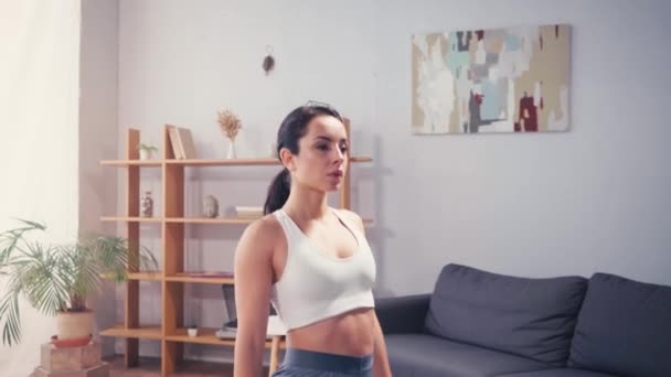 Sportswoman breathing while doing lunge on fitness mat at home  - Footage, Video