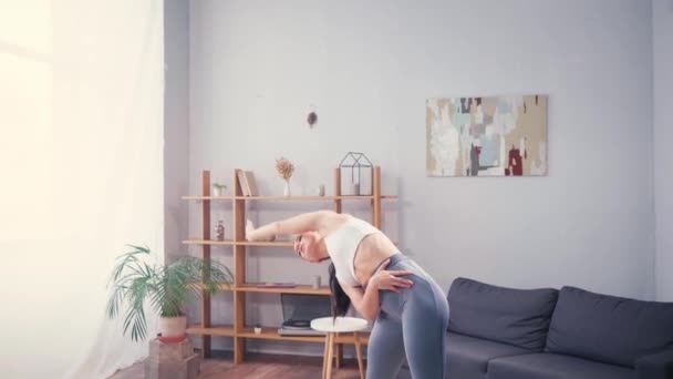 Çıplak ayaklı sporcu kadın evde egzersiz yaparken eğiliyor.  - Video, Çekim