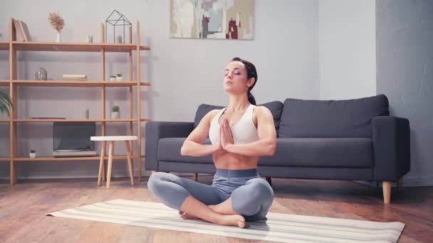 Sportvrouw doet ademhalingsoefening terwijl ze thuis mediteert  - Video