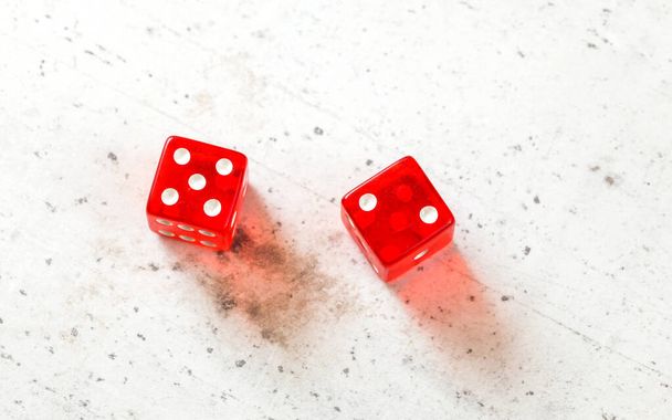 Two red craps dices showing Natural or Seven Out (number 5 and 2) overhead shot on white board - Foto, Imagen