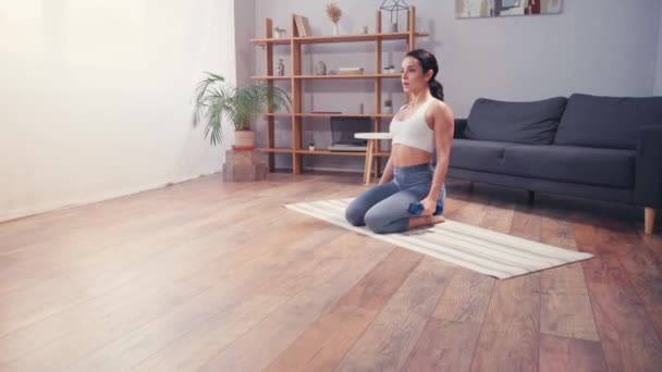 Sportiva scalza che si allena con i manubri sul tappeto fitness a casa  - Filmati, video