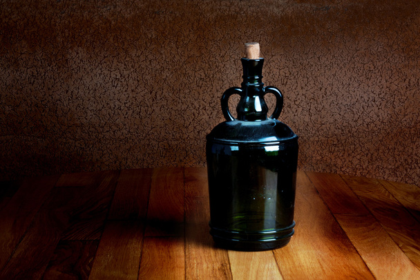 Old dusty bottle on a wooden table vintage - Фото, зображення