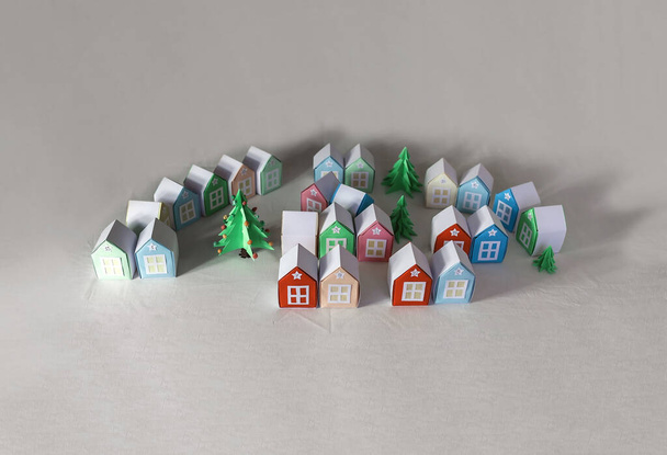 Origami advent calendar. Miniature with Christmas tree and paper houses. Isolated on grey background, seasonal craft activity with kids - Photo, Image