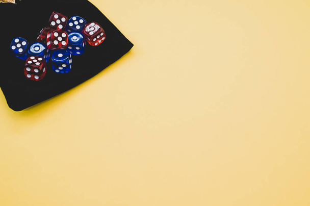 A top view of red and blue dice on dice bag isolated on yellow background - Foto, immagini