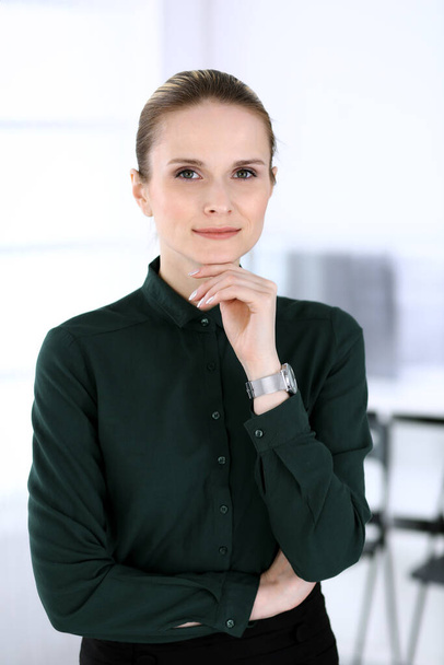 Business woman headshot in modern office. Secretary or female lawyer standing straight and looking at camera. Business people concept - Фото, изображение