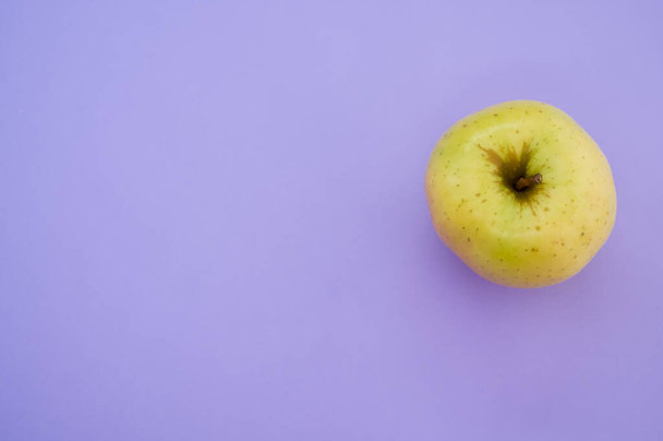 A top view of yellow apple isolated on purple background - Foto, Imagen