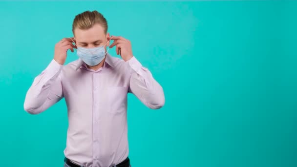 Όμορφος άνδρας φορώντας μια ιατρική μάσκα στο πρόσωπό του για να αποτρέψει την εξάπλωση του Viruss. - Πλάνα, βίντεο