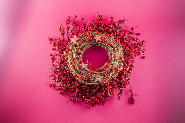 A red Christmas wreath on a pink background - Photo, Image