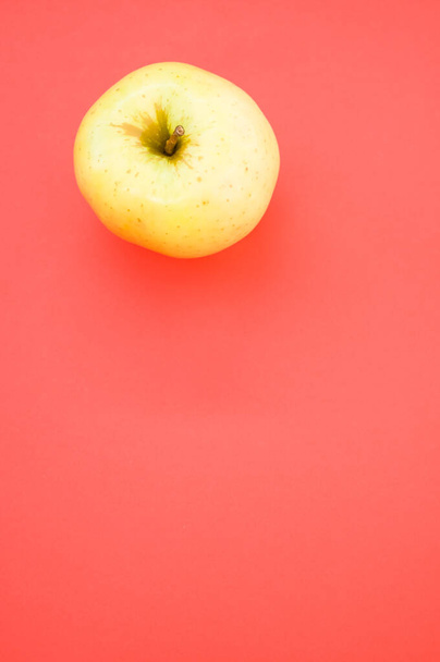 A vertical shot of yellow apple isolated on pink background - Foto, Imagem