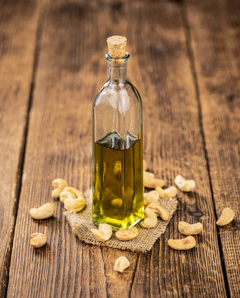 Fresh made Cashew Oil on an old wooden table (close-up shot; selective focus) - Фото, зображення
