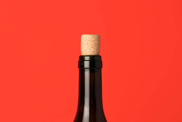 Großaufnahme der Weinflasche mit Korken. Weinkappe auf rotem Hintergrund. Minimales Konzept - Foto, Bild