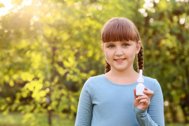 Little allergic girl with remedy outdoors - Фото, зображення