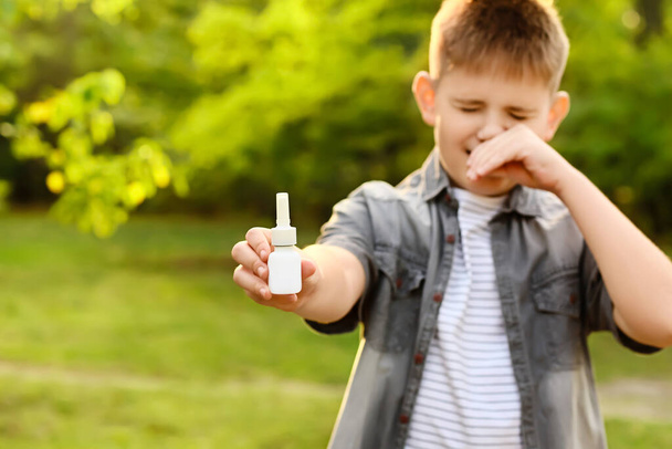 Маленький алергічний хлопчик з ліками на відкритому повітрі
 - Фото, зображення
