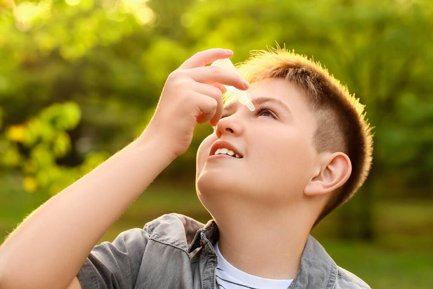Petit garçon allergique utilisant des gouttes pour les yeux à l'extérieur - Photo, image