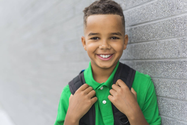 cheerful african american primary school boy with backpack - 写真・画像