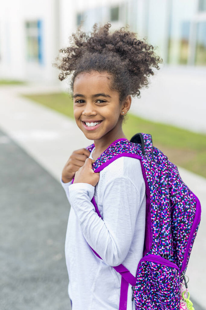 cheerful african american primary school girl with backpack - Φωτογραφία, εικόνα
