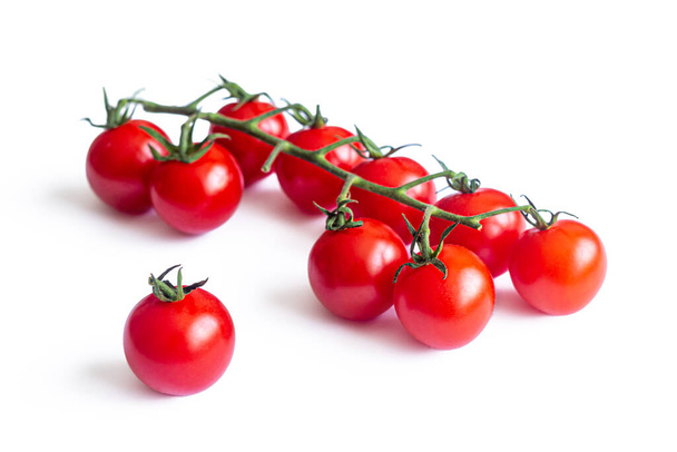 Pequenos tomates cereja vermelhos, em uma fina escova de frutas verde, isolados em um fundo branco - Foto, Imagem