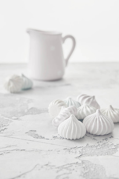 Meringues of a delicate pastel color are on the table for morning tea. - Фото, изображение